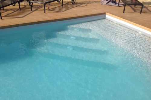 scala di accesso alla piscina da area relax immersa (carabottino immerso di una copertura a tapparella) di forma triangolare diritta
