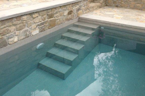 piscina in cemento armato isolato rivestita in mosaico perla con scala di ingresso in opera